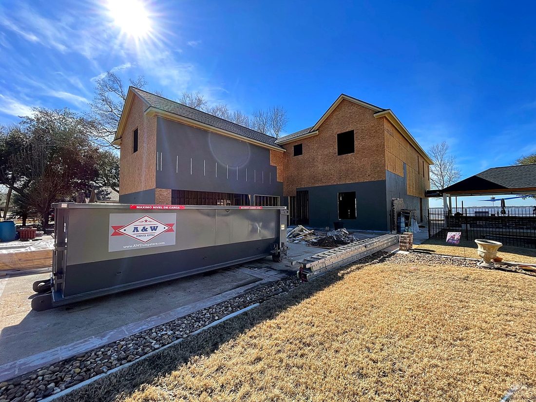 A&W roll-off dumpster at a new-construction home near Conroe