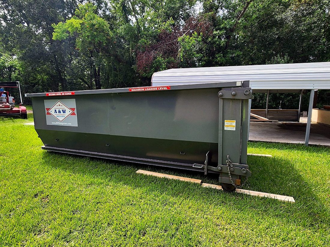 A&W roll-off dumpster in a residential yard near Willis